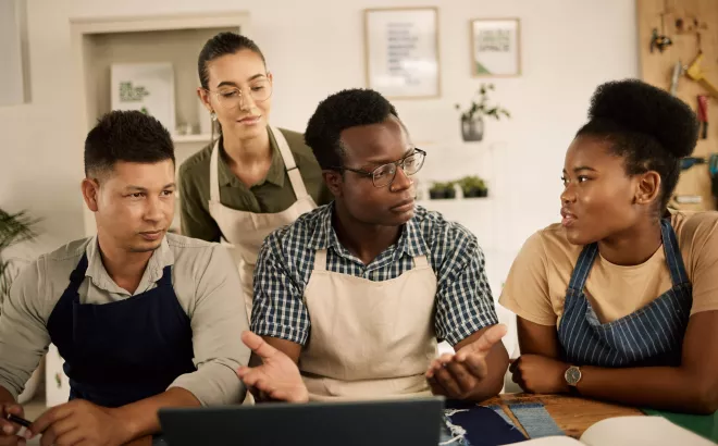 Group of people discussing in front of a laptop screen